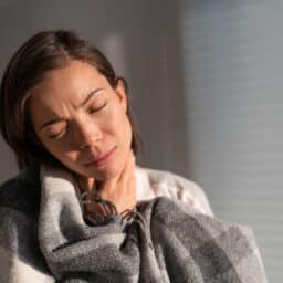 Woman holding her sore throat