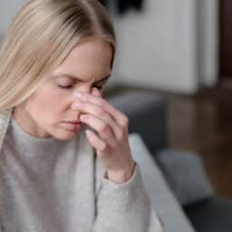 Woman holding her congested nose