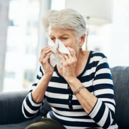 Woman blowing her nose into a tissue