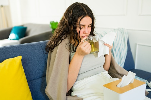 Woman drinking a warm cup of tea on the couch